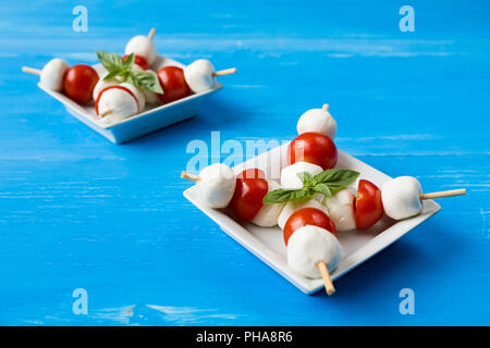 Skewers with mozzarella, cherry tomatoes and basil Stock Photo