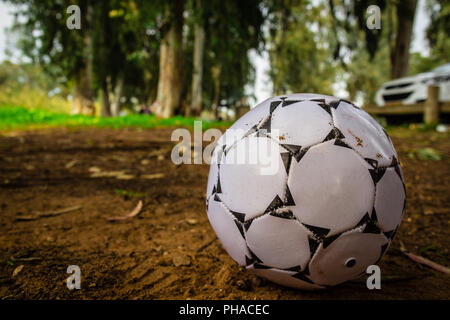 Black and white soccer ball on brown sand Stock Photo