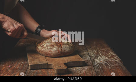 Men's hands cut bread Stock Photo