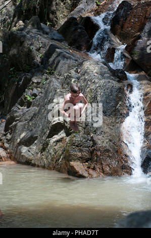 Child jumping in waterfall Stock Photo