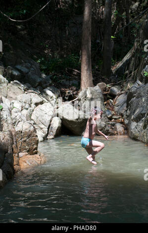 Child jumping in waterfall Stock Photo