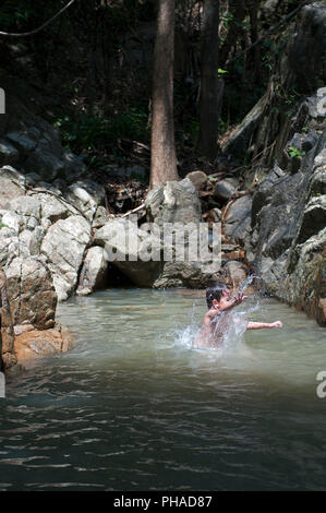 Child jumping in waterfall Stock Photo