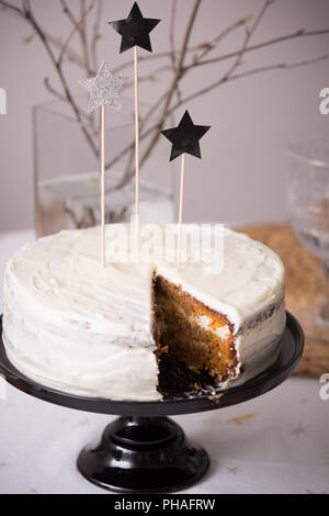 Close up of delicious homemade birthday white cake decorated with silver stars on the table. Baking at home for events. Cooking sweet cake for holiday Stock Photo