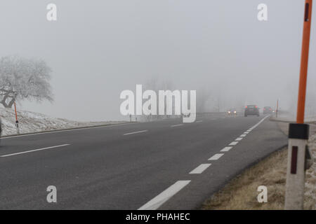 Cars drive in the fog on slippery road Stock Photo