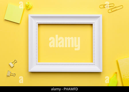 White Frame with Office Accessories on Yellow Background Stock Photo