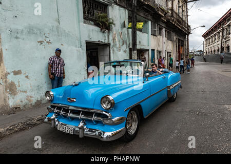Young tourist sitting in back seat of classic car on tour of Old Havana, Cuba. Stock Photo
