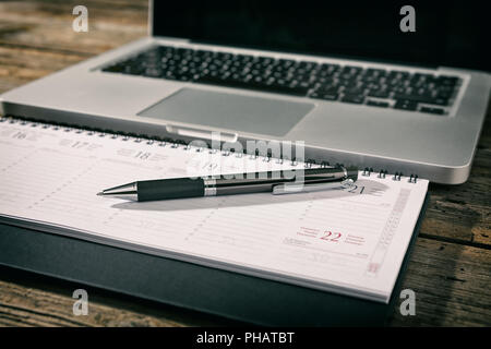 Office workstation with laptop, agenda and pen Stock Photo