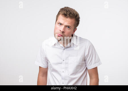 Young man dissatisfied frowns and looks sullenly. Wrinkles on the forehead of negative events Stock Photo