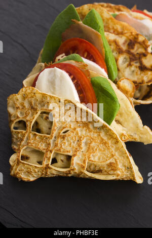 Pancakes sutffed with ham, cheese, tomatoes and spinach Stock Photo