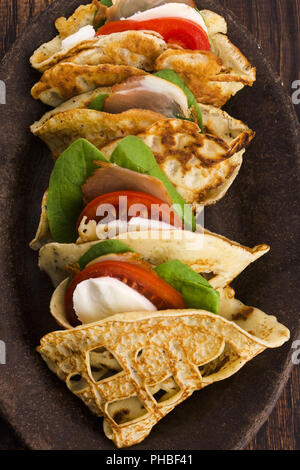 Pancakes sutffed with ham, cheese, tomatoes and spinach Stock Photo