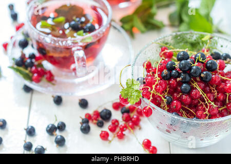 Fresh red and black currant in glass vase Stock Photo