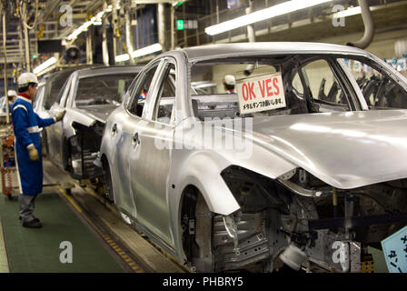 A worker checks for faults in the body of a vehicle at Nissan Motor Co.s body plant in Tochigi, Japan on Thursday 12 Nov.  2009.  Photographer: Robert Stock Photo