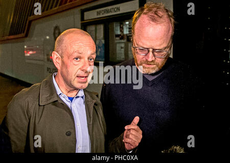 Investigative journalists Barry McCaffrey (left) and Trevor Birney (right) outside Musgrave Street police station in Belfast. Stock Photo