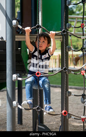 Child climbing on a rope ladder Stock Photo