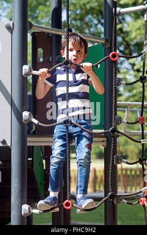 Child climbing on a rope ladder Stock Photo
