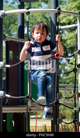Child climbing on a rope ladder Stock Photo