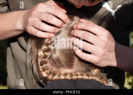 Head lice infection common in young people. Hair being checked using a special head lice comb. Stock Photo