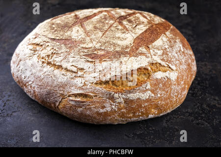 Freshly backed Farmhouse Bread as close-up on an old griddle Stock Photo