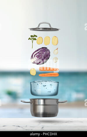 Fresh vegetables falling into stainless steel pot Stock Photo