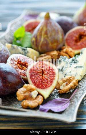 Ripe figs, walnuts and blue cheese on the tray. Stock Photo