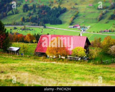 Tilt shift picture of a house with red roof on a hill Stock Photo