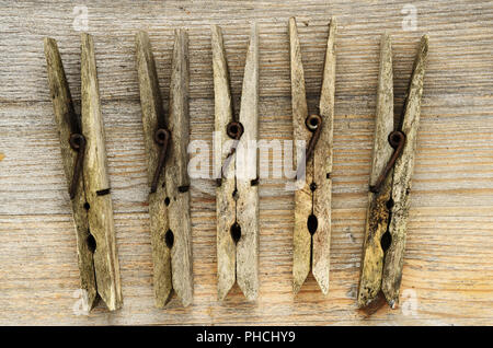 dirty old clothespins on a wooden board Stock Photo