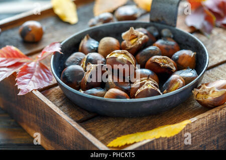 Roasted chestnuts in a cast iron skillet. Stock Photo