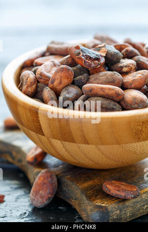 Organic cocoa beans in a wooden bowl. Stock Photo