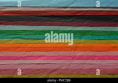 A brightly coloured, striped,  tissue paper background with copy space. Stock Photo