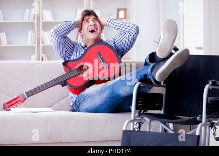 Disabled man playing guitar at home Stock Photo