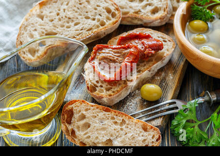 Fresh ciabatta, olives, oil and sun-dried tomatoes. Stock Photo