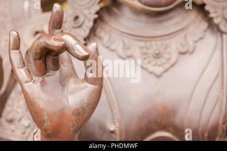 Detail of Buddha statue with Karana mudra hand position Stock Photo