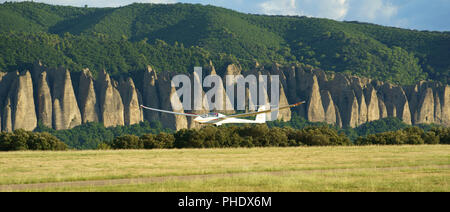 Sailplane on final approach with the rock formation of les Mées in the background. Château-Arnoux-Saint-Auban Airfield, Provence, France. Stock Photo