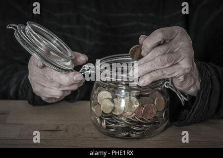 Hands hold a mason jar with small change Stock Photo