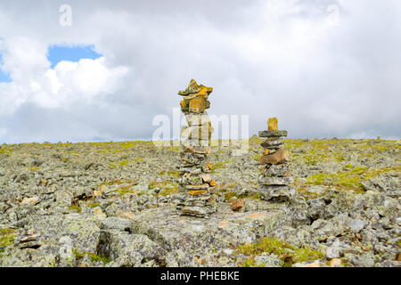 Two towers at the top of the Sarlyk mountain from the stones stacked on each other, balancing in the air, indicating the way for tourists and pilgrims Stock Photo