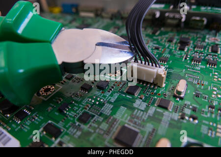 The technician is cutting the circuit of amplifier at office. Concept of repairing technology equipment. Maintenance business. Component of circuit. E Stock Photo