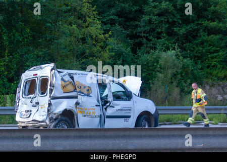Fast Parcel Delivery Van of Slovenian Post wrecked in car crash on Styrian Highway A1 near Blagovica, Fireman walking toward the vehicle Stock Photo