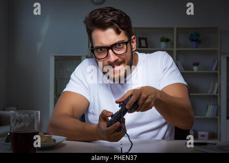 Young man playing games long hours late in the office Stock Photo