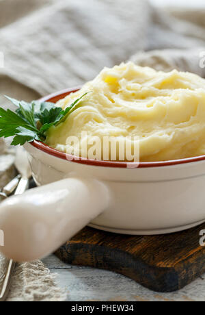 Mashed potatoes and green parsley in a ceramic bowl. Stock Photo