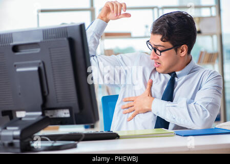 Businessman suffering from excessive armpit sweating Stock Photo