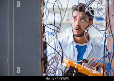 Electrician trying to untangle wires in repair concept Stock Photo