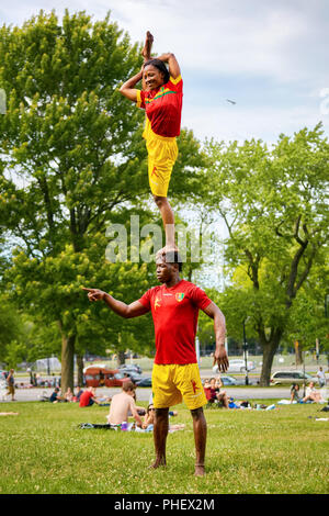 African couple performing acrobatics show in front of the audience in Mount Royal Park, Montreal, Quebec, Canada Stock Photo