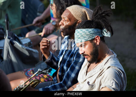 Montreal, Canada - June, 2018. Portrait of a young handsome hispanic latino and an African American male trumpet player sitting next to each other. Mu Stock Photo