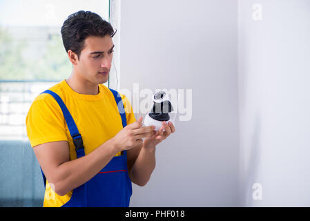 Contractor installing surveillance CCTV cameras in office Stock Photo