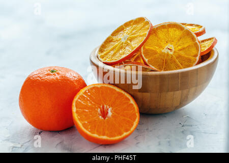 Dry orange and lemon slices in a wooden bowl. Stock Photo