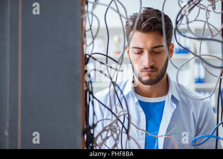 Electrician trying to untangle wires in repair concept Stock Photo