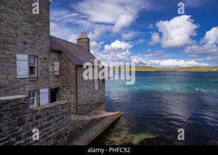 Old stone house by the sea at Lerwick, Shetland Isles, Scotland on a sunny day Stock Photo
