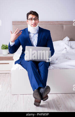 Businessman with neck injury working from home Stock Photo