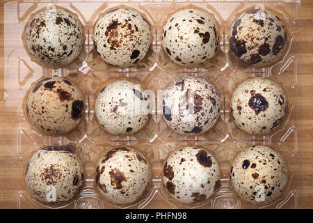 Quail Eggs in Plastic Container on Wood Background Stock Photo