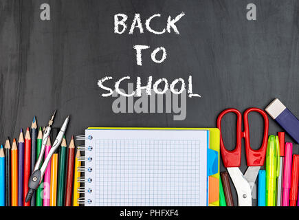 School suppiles on black board background. Stock Photo